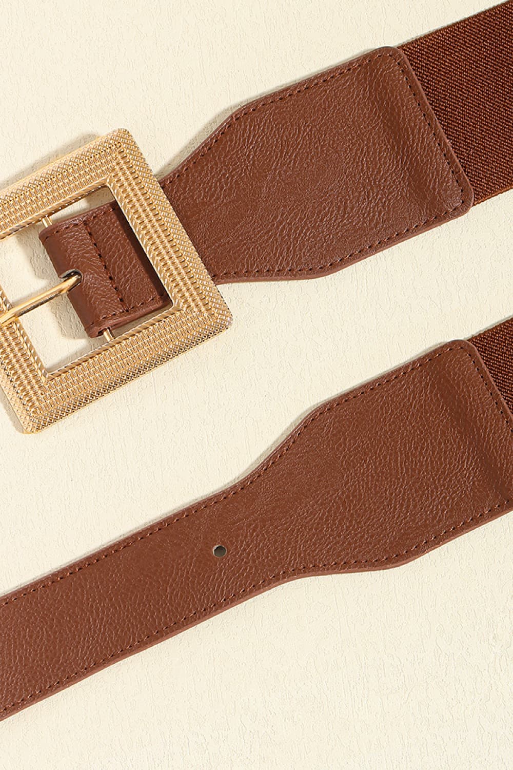 Brown elasticated waist belt with textured gold square buckle and faux leather detailing.