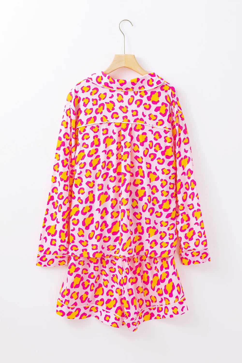 Pink leopard print satin pajama set with collared top and shorts.