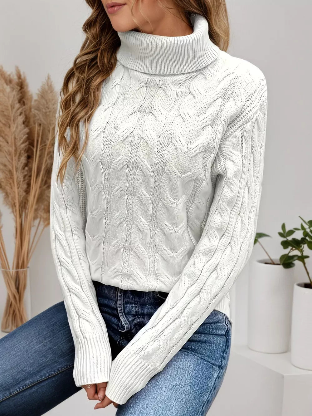 White cable-knit turtleneck sweater with a cozy, textured design.