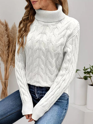 White cable-knit turtleneck sweater with a cozy, textured design.