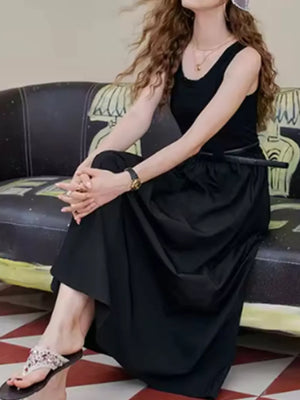 Black fitted midi dress with a flowing skirt and scoop neck.