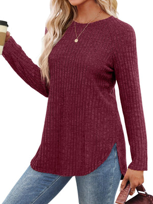 Burgundy ribbed sweater with raglan sleeves and asymmetric hem detail.