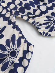 Maxi dress with blue floral print, cutout waist detail, and smocked elastic trim.