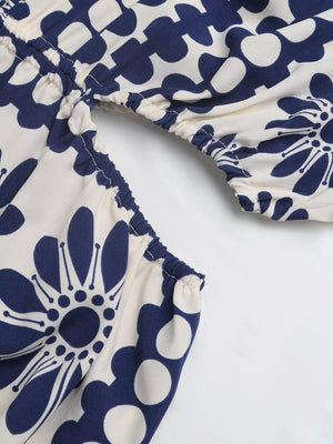 Maxi dress with blue floral print, cutout waist detail, and smocked elastic trim.
