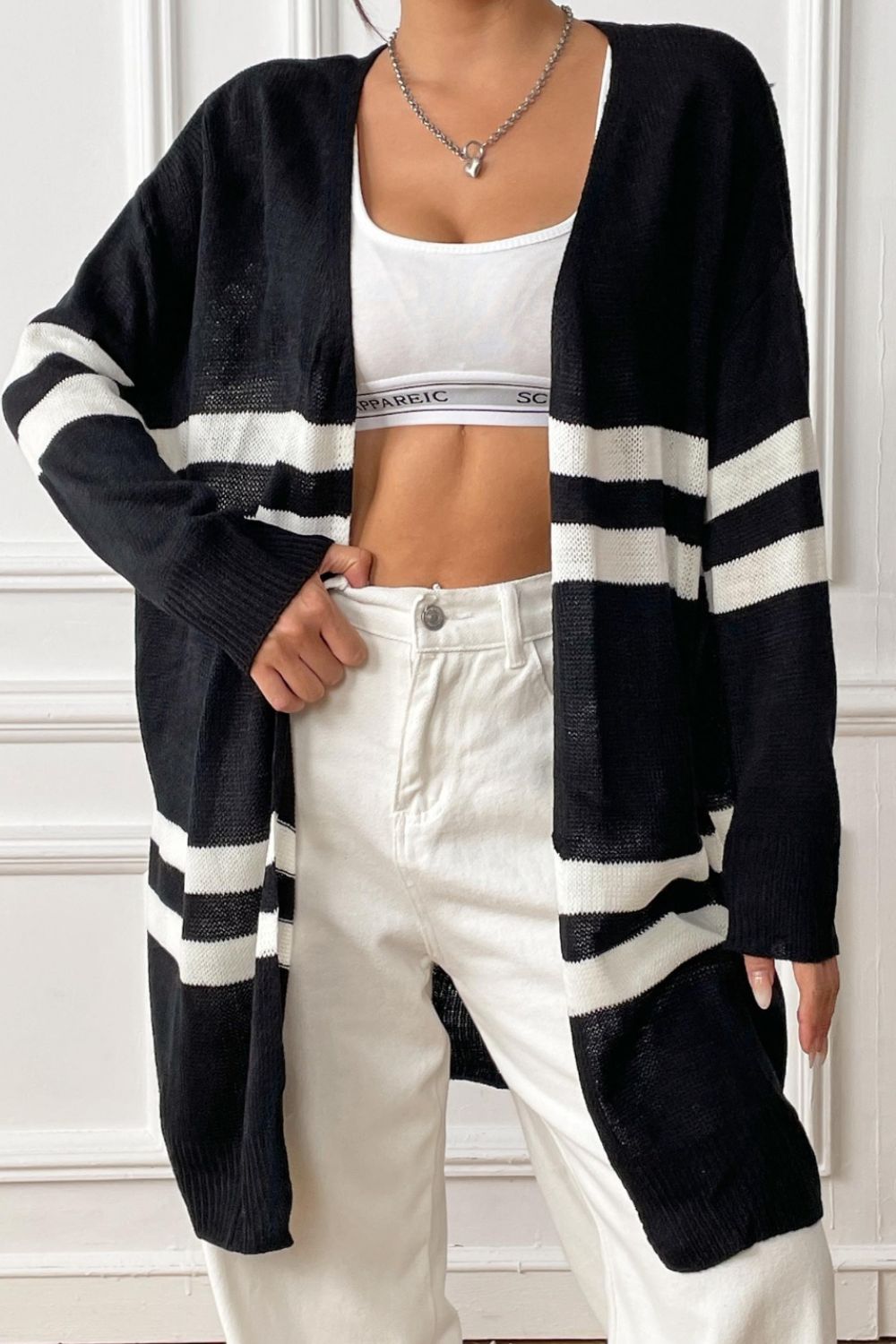 Oversized black and white stripe knit cardigan with open front and long sleeves.