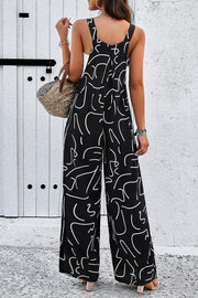 Black wide leg jumpsuit with abstract white scribble print, square neckline, and adjustable straps.