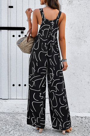 Black wide leg jumpsuit with abstract white scribble print, square neckline, and adjustable straps.