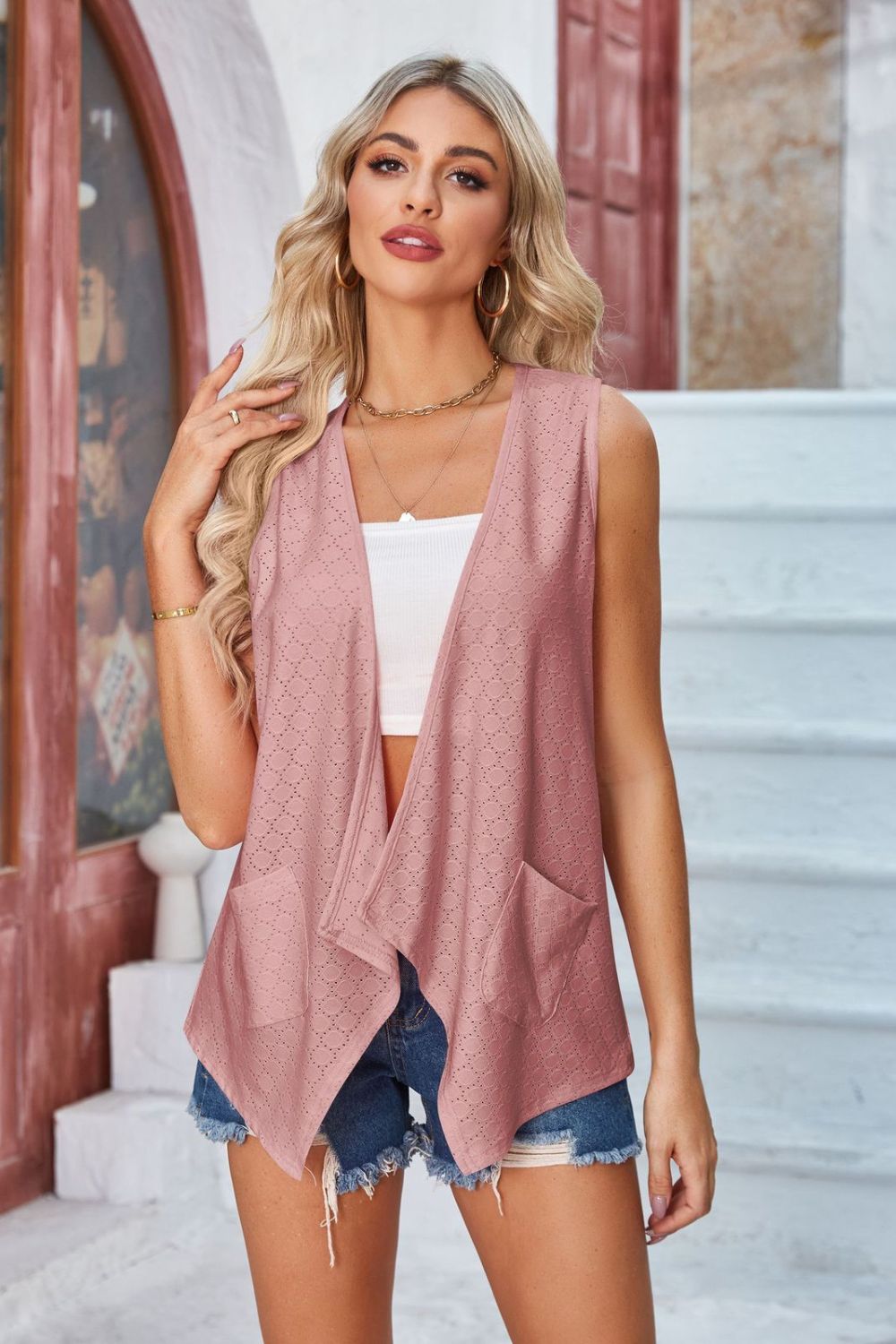 Blush pink eyelet drape front vest with pockets and open waterfall neckline.
