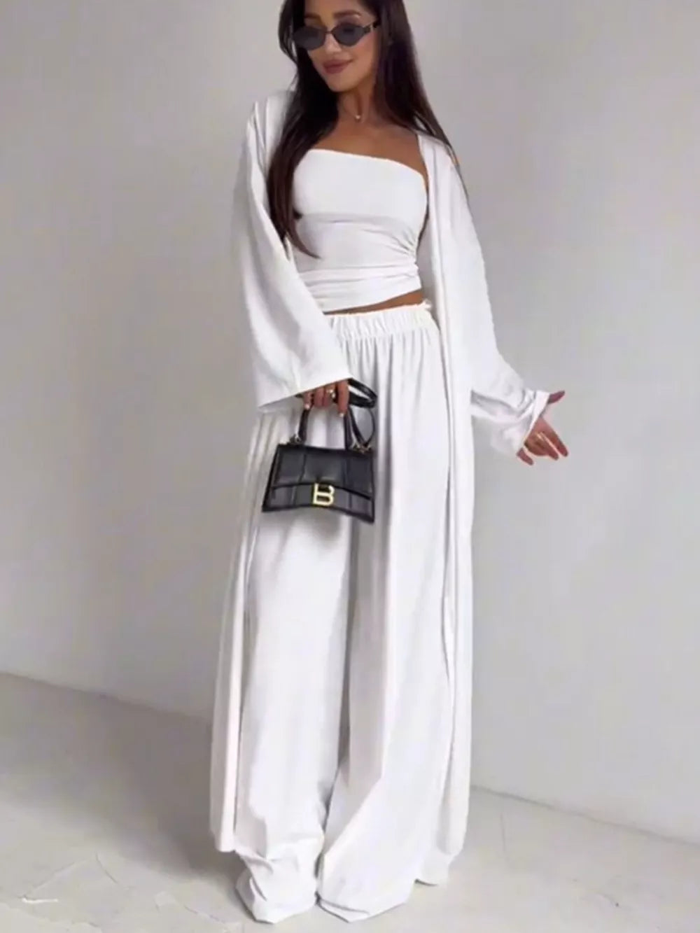 White three-piece maternity set with crop top, wide-leg pants, and open cardigan.