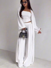White three-piece maternity set with crop top, wide-leg pants, and open cardigan.