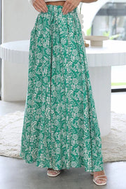 Green botanical print palazzo trousers with a drawstring waist and wide leg.