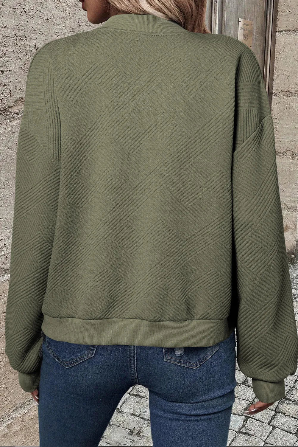 Textured quilted bomber jacket in sage green with a geometric pattern and ribbed cuffs.