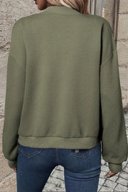 Textured quilted bomber jacket in sage green with a geometric pattern and ribbed cuffs.