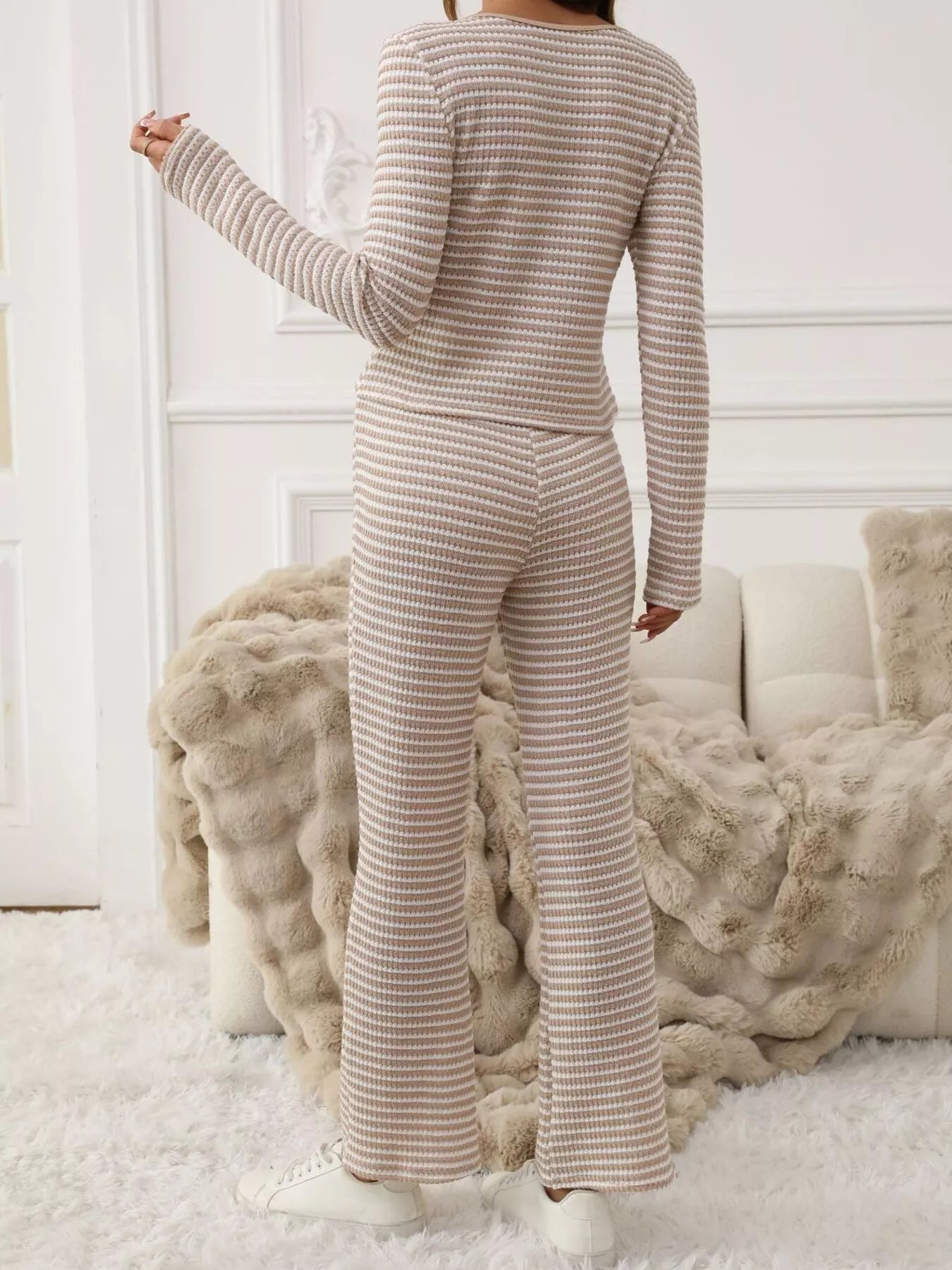 Tied two-piece set in apricot with horizontal stripes, long sleeves, and flared pants.