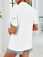 White eyelet ruched short sleeve blouse with a collared neckline.