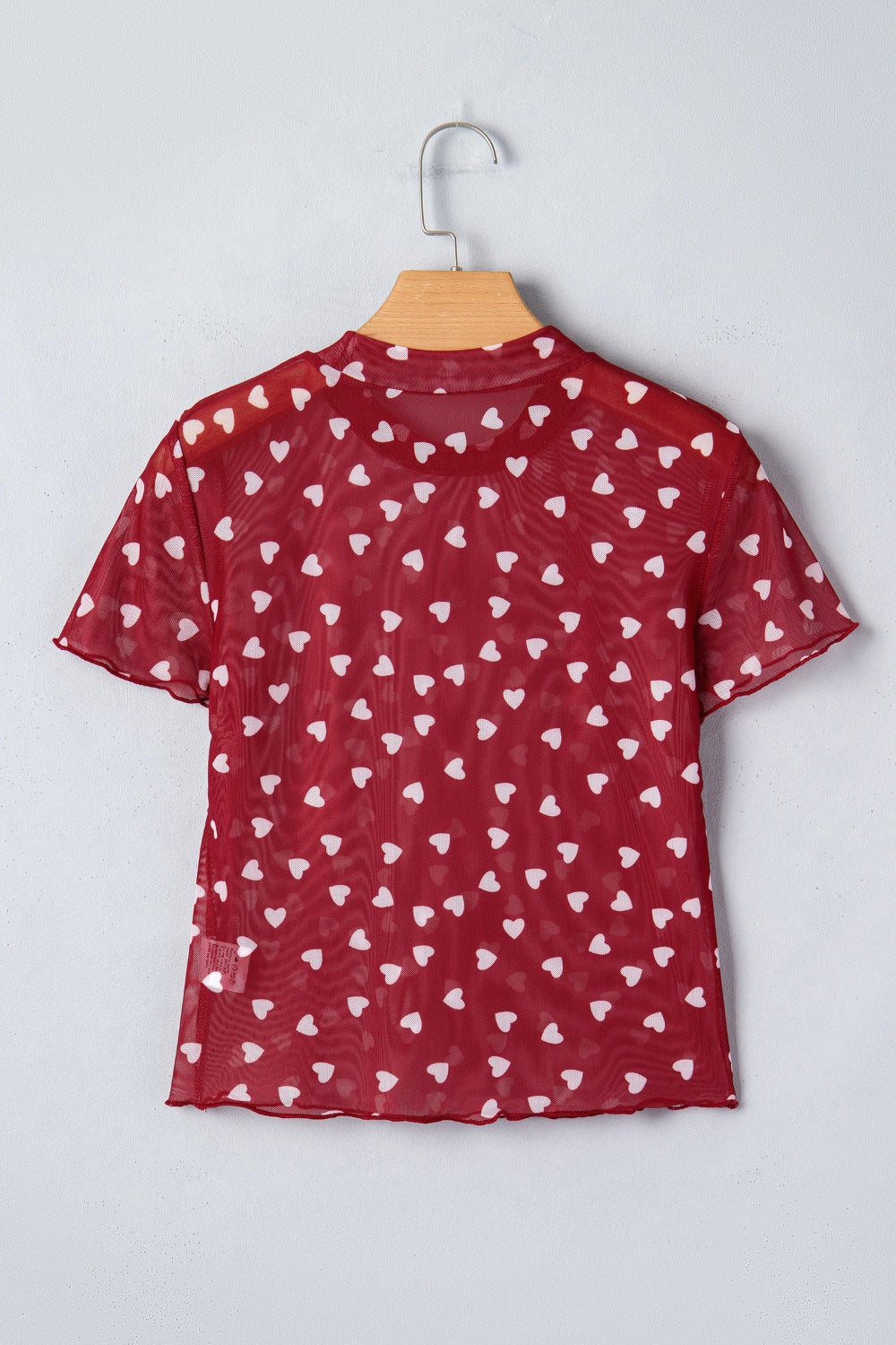 Deep red sheer mesh t-shirt with white heart print, short sleeves, and lettuce hem.