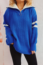 Ribbed knit quarter-zip sweater in royal blue with white stripes on sleeves and cream collar.