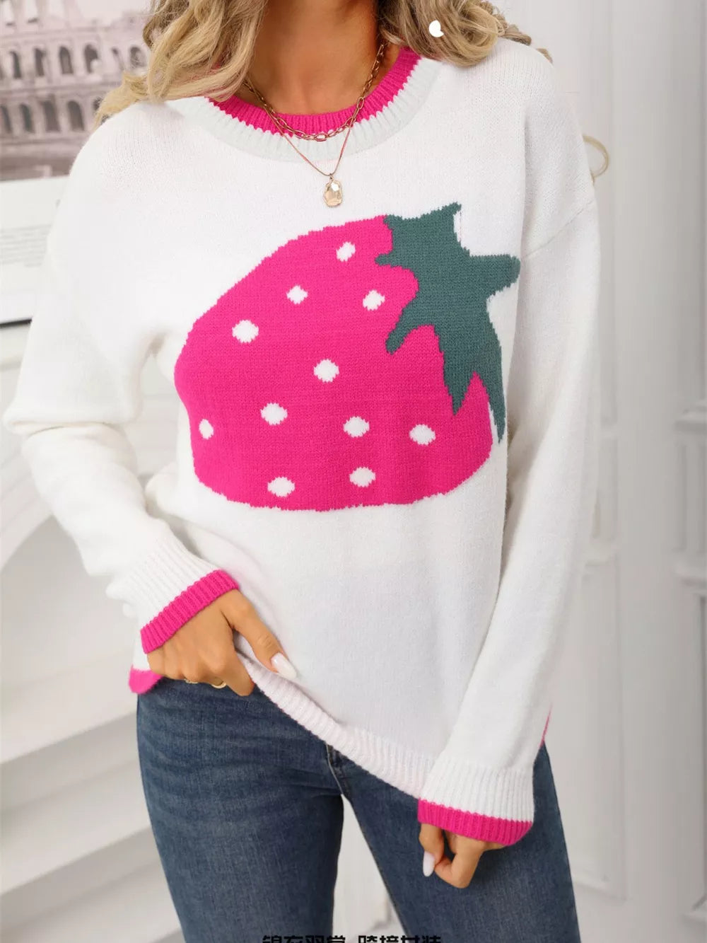 White acrylic blend sweater with a large pink strawberry graphic and pink trim.