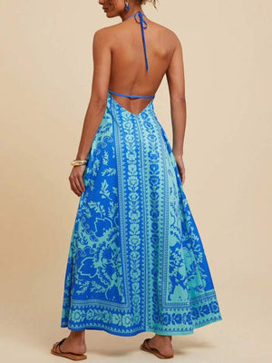 Blue floral halter maxi dress with open back and flowing skirt.