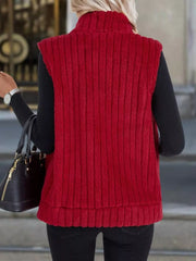Red fleece zip-up vest with vertical ribbing and mock neck, worn over black sweater.