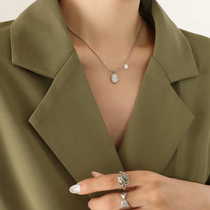 Silver necklace with oval medallion and pearl accent