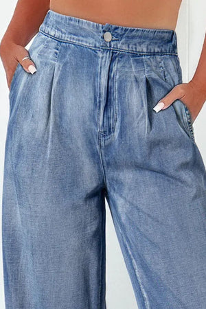 Pleated waist palazzo denim trousers in medium wash, with a relaxed fit and wide legs.