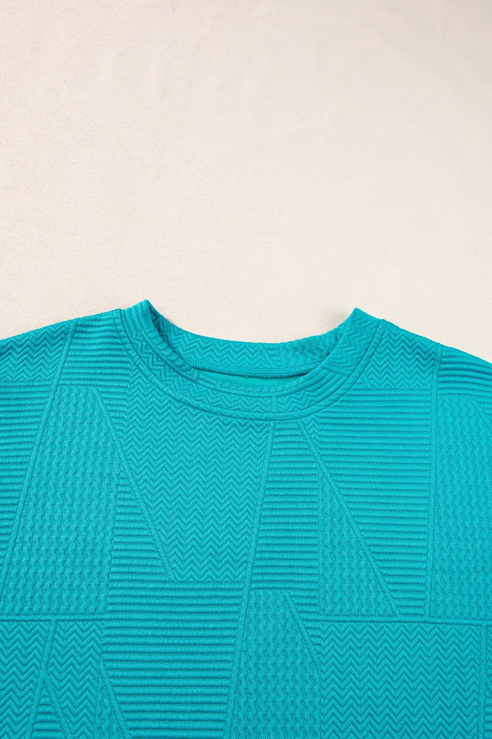 Turquoise textured co-ord set with geometric pattern and crew neck.