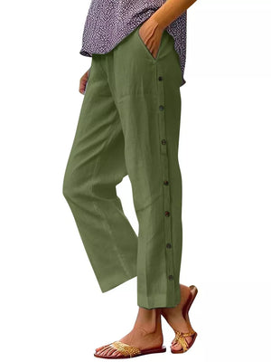 Green relaxed fit pants with decorative buttons down the side and pockets.