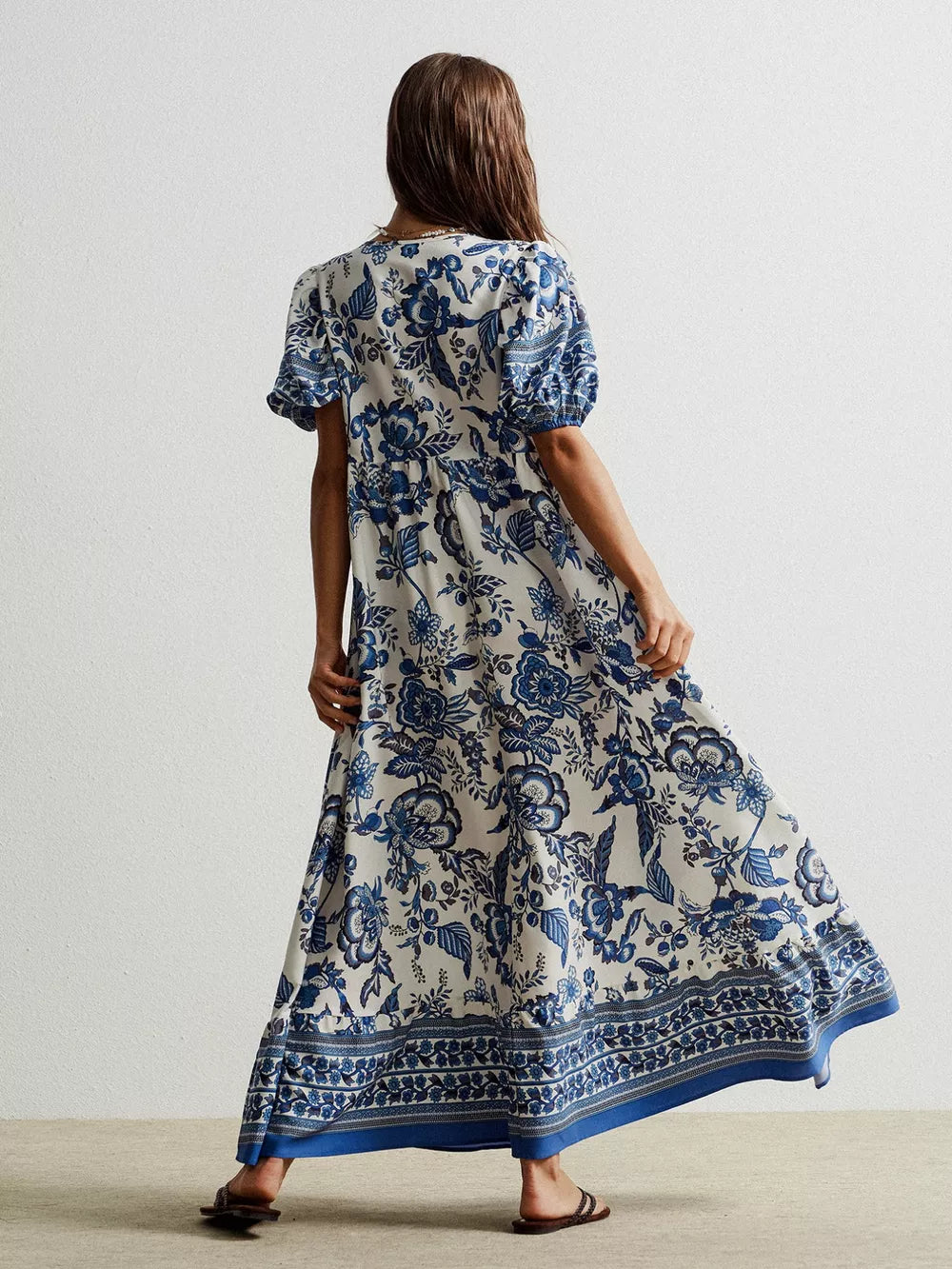 Maxi dress with blue floral print, short sleeves, and tie-neck detail.