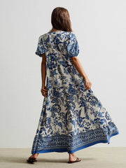 Maxi dress with blue floral print, short sleeves, and tie-neck detail.