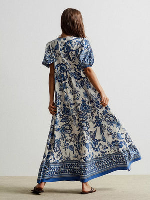 Maxi dress with blue floral print, short sleeves, and tie-neck detail.