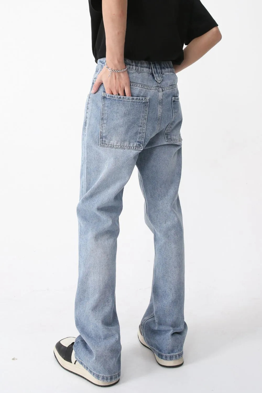 Medium wash wide-leg denim jeans with carpenter pocket detail