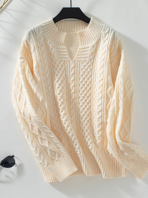 Cream cable knit sweater with keyhole neckline and ribbed cuffs.