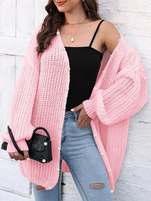 Pink balloon sleeve cardigan with pearl buttons and open knit detail.