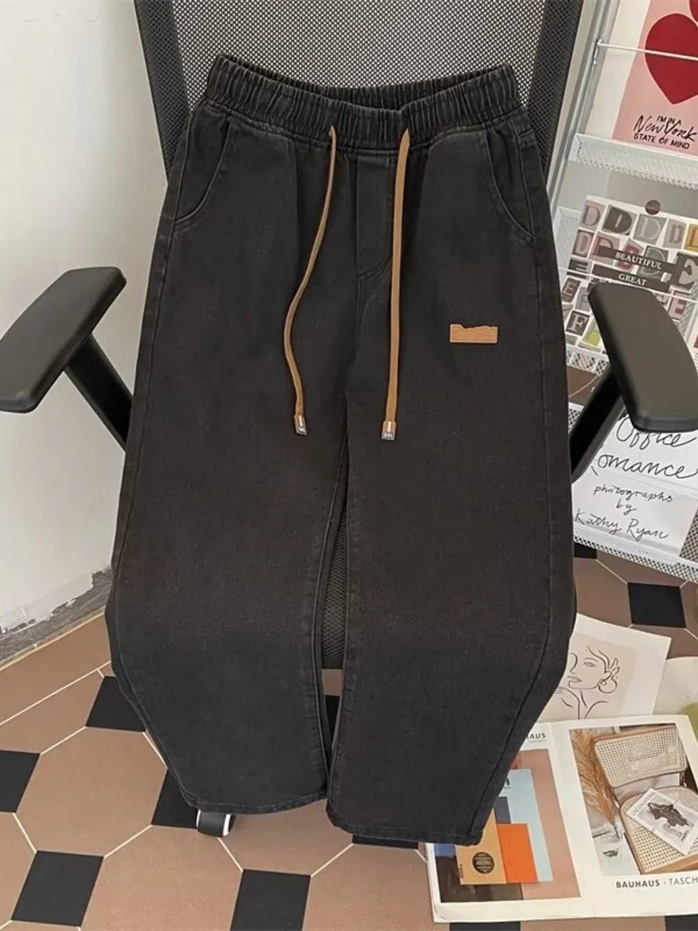 Black wide-leg jeans with elastic waistband and drawstring, casual denim pants.