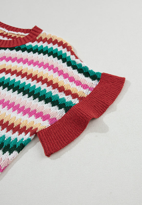 Textured knit sweater with multicolor chevron stripes and contrast red trim on sleeves and neckline.