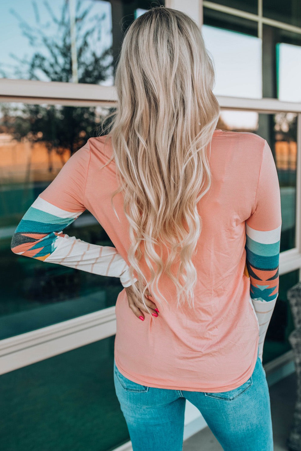 Crewneck shirt in pink with Aztec print sleeve panels and striped accents.
