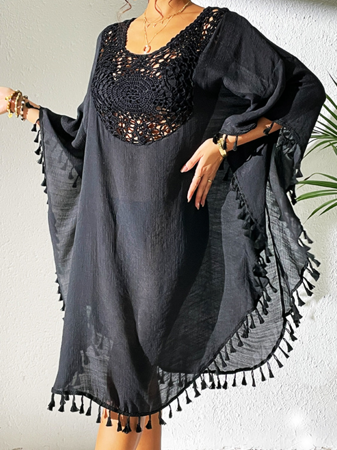 Black crochet yoke tassel kaftan dress with wide sleeves and a flowing hem.