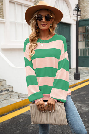 Oversized knit sweater with balloon sleeves in green and pink stripes.