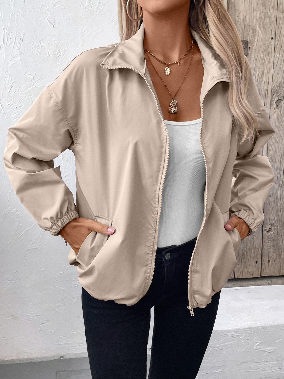 Nylon bomber jacket in beige with zip front, elastic cuffs, and drawstring hem detail.