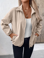 Nylon bomber jacket in beige with zip front, elastic cuffs, and drawstring hem detail.