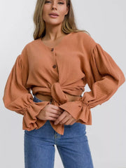 Ochre textured puff sleeve blouse with ruffled cuffs and tie front.