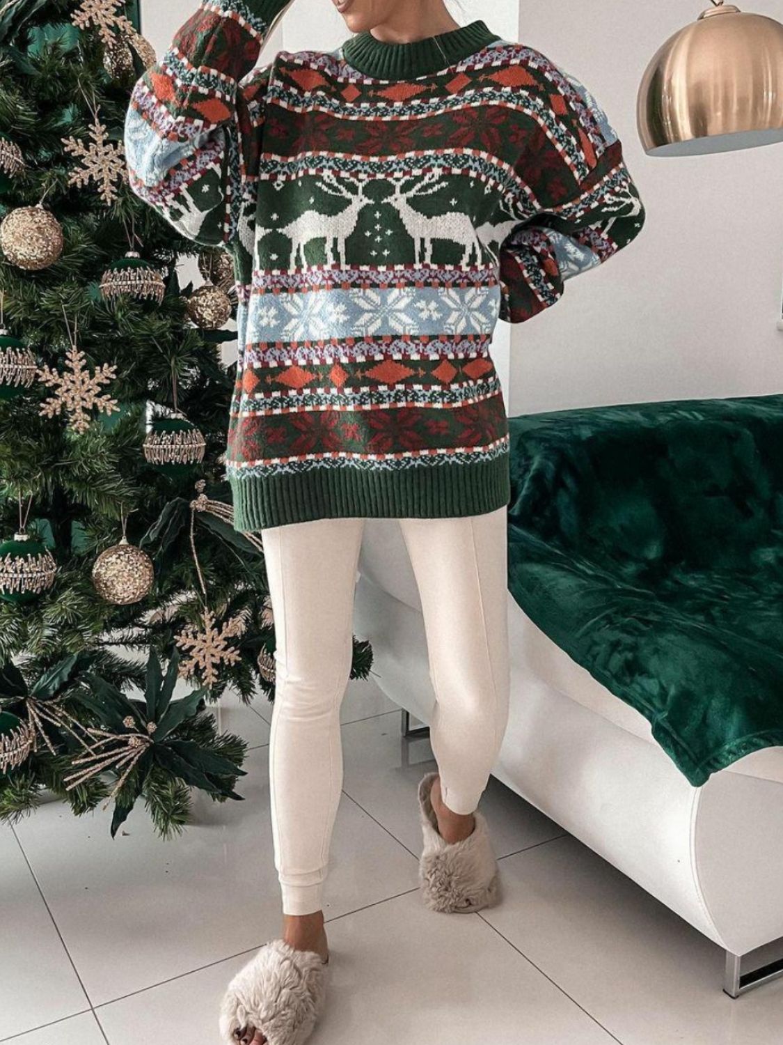 Fair Isle knit sweater with reindeer and snowflake motif in green, brown, and cream.