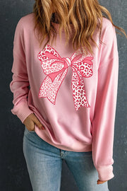 Blush pink sweatshirt with a pink leopard print bow graphic and crew neck.