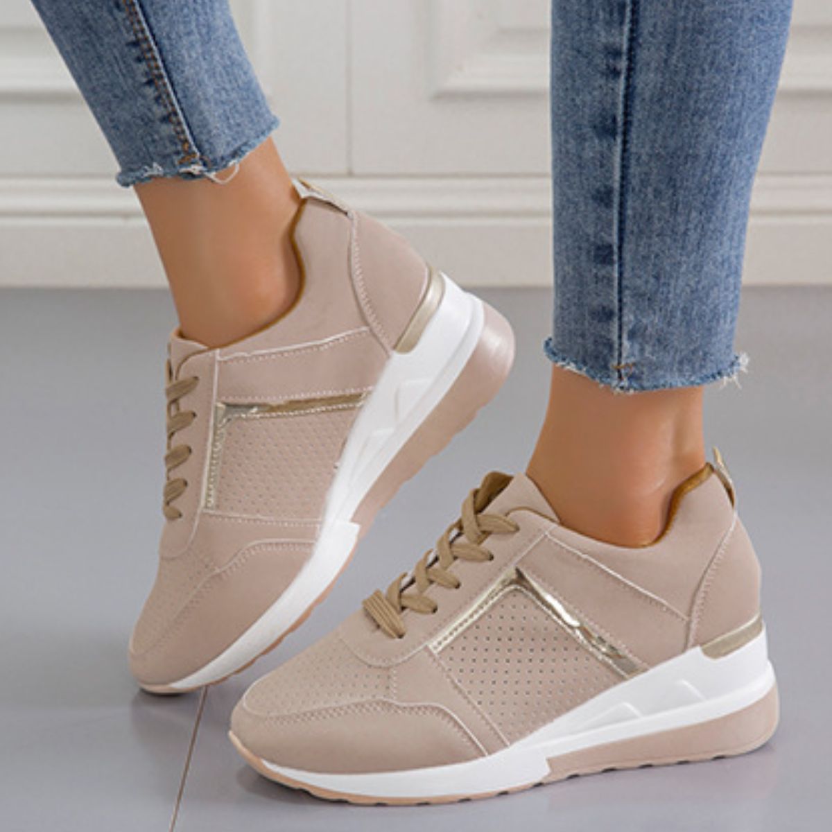 Beige lace-up wedge sneakers with metallic accents and perforated details.