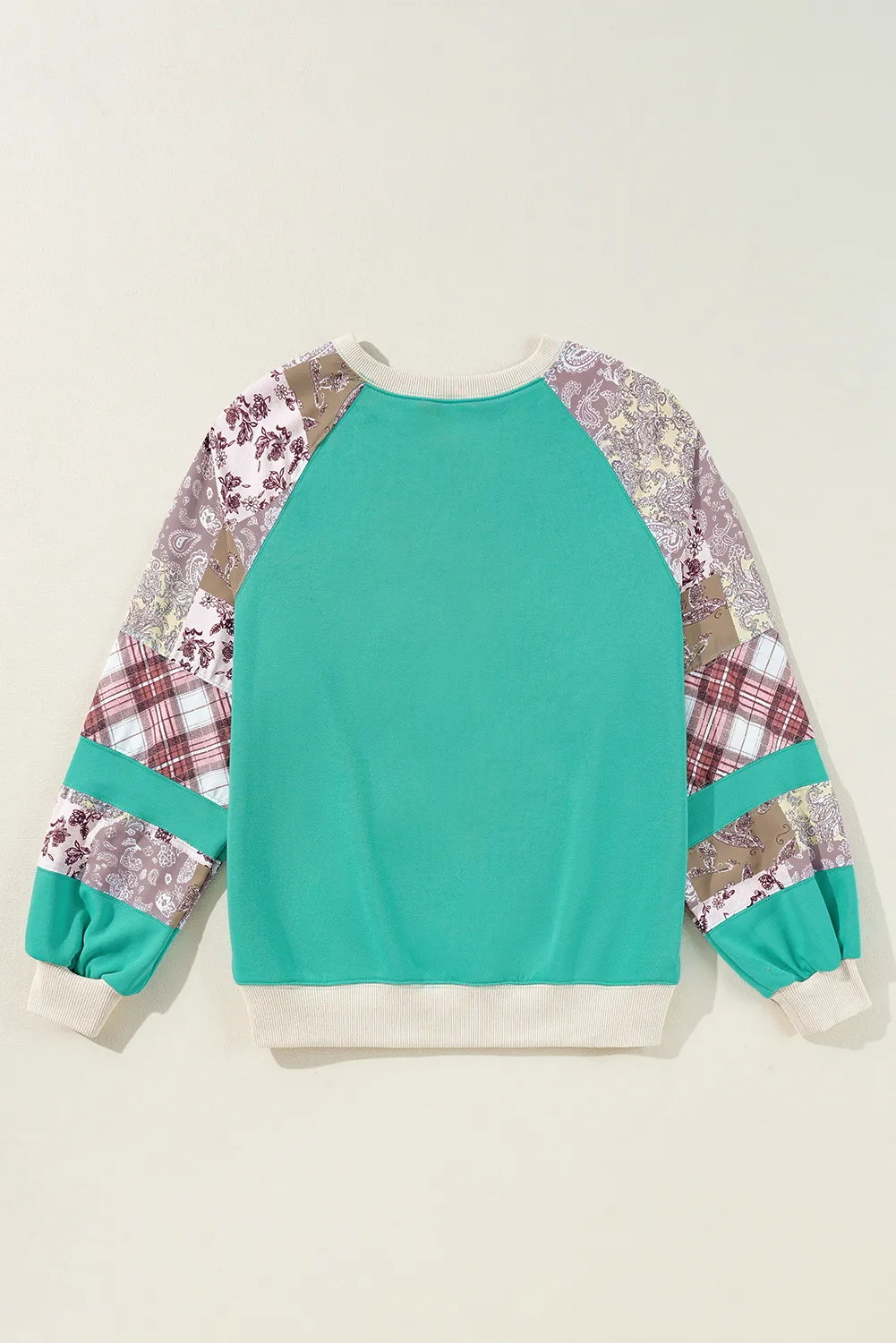 Turquoise patchwork raglan sleeve sweatshirt with paisley and plaid details.