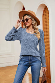 Textured blue knit blouse with square neckline and cuffed sleeves.
