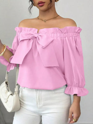 Pink off-shoulder blouse with ruffled bow detail and bell sleeves.