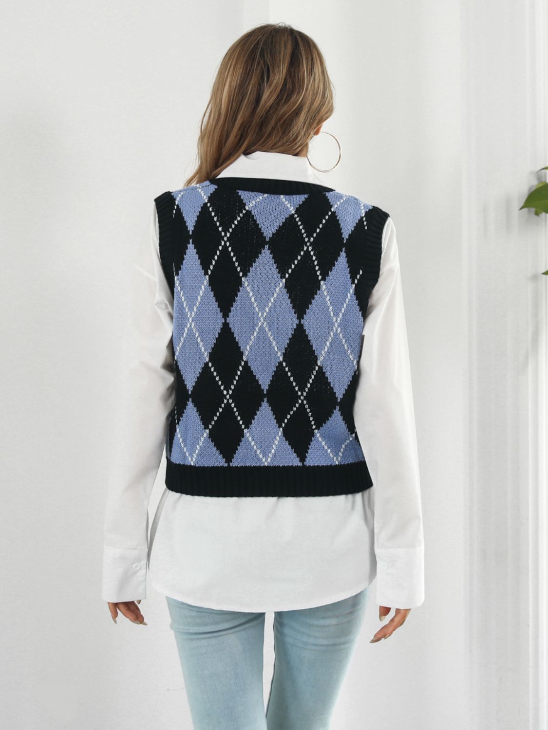 Black argyle knit vest with blue and white diamond pattern, acrylic material.