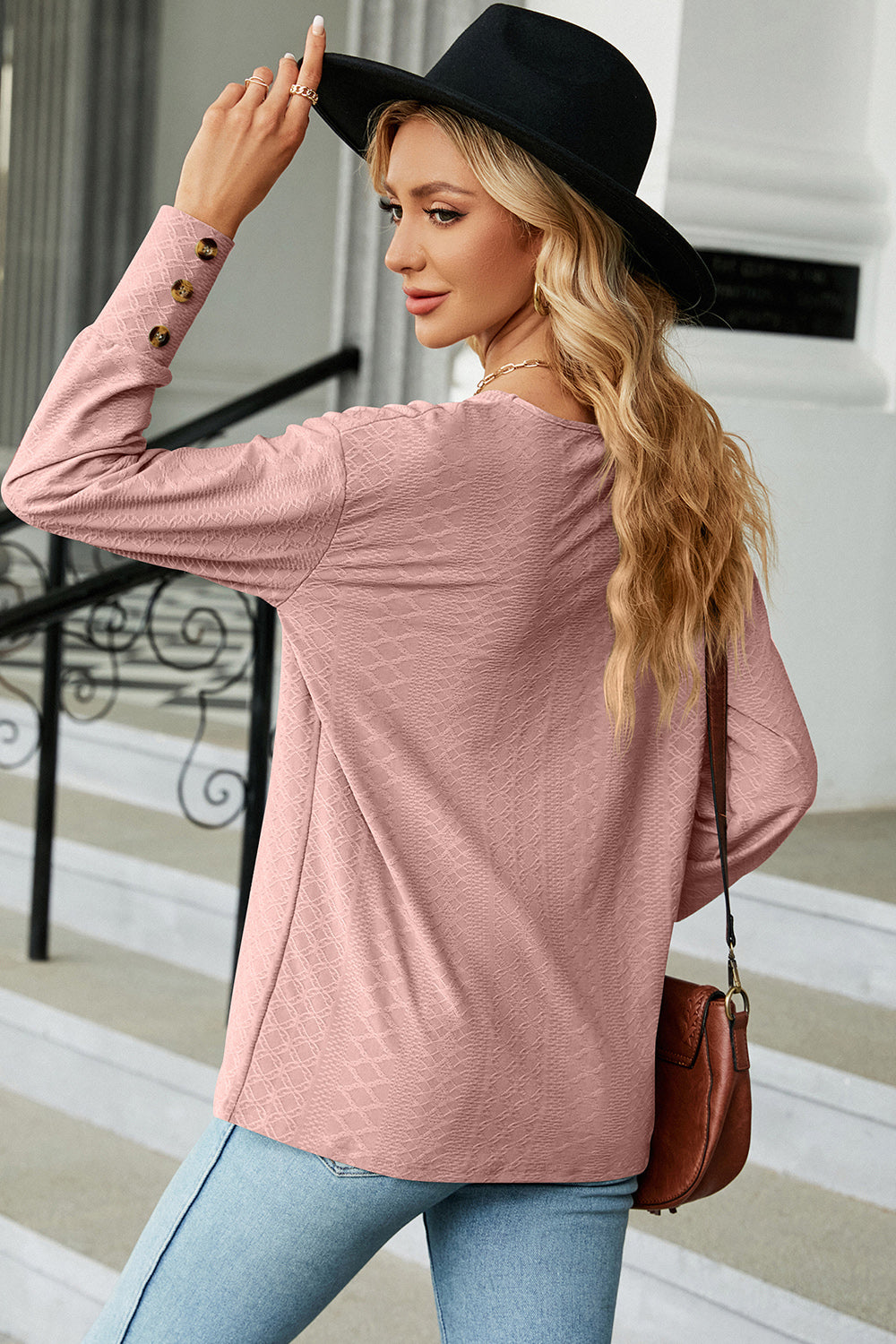 Blush pink blouse with diamond texture, V-neck, and button cuff sleeves.